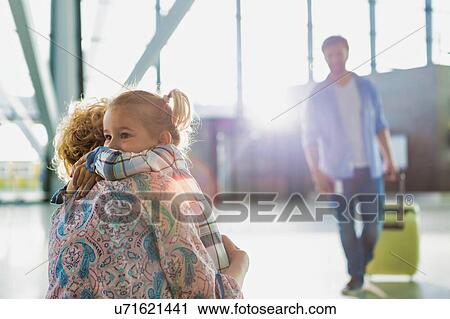 Stock Image - Portrait of woman reuniting with her daughter in airport. Fotosearch