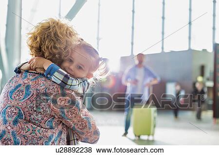 Portrait of woman reuniting with her daughter in airport View Large Photo Image Stock Photo - Portrait of woman reuniting with her daughter in airport. Fotosearch