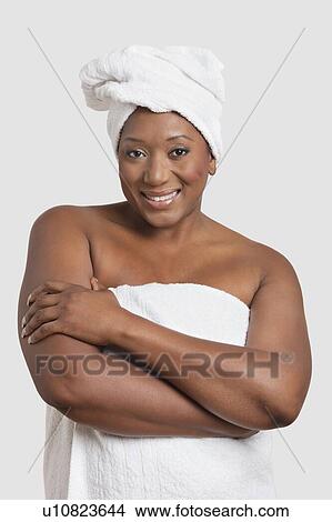 Picture - Portrait of woman with body and head wrapped in towels over white background. Fotosearch