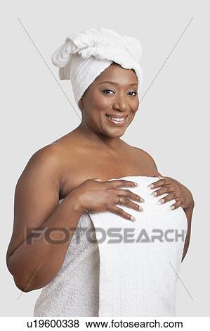 Stock Photo - Portrait of woman with body and head wrapped in towels over white background. Fotosearch