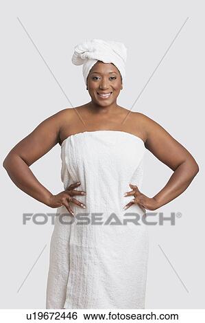 Stock Photograph - Portrait of woman with body and head wrapped in towels over white background. Fotosearch