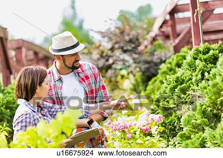 Picture - Portrait of woman writing report on plants in garden shop. Fotosearch