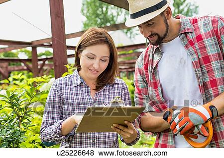 Portrait of woman writing report on plants in garden shop View Large Photo Image Stock Photo - Portrait of woman writing report on plants in garden shop. Fotosearch