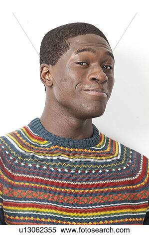 Stock Photography - Portrait of young African American man making funny faces against white background. Fotosearch