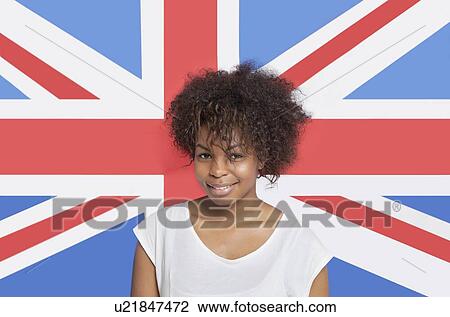 Portrait of young African American woman in white t-shirt smiling against British flag View Large Photo Image Stock Image - Portrait of young African American woman in white t-shirt smiling against British flag. Fotosearch