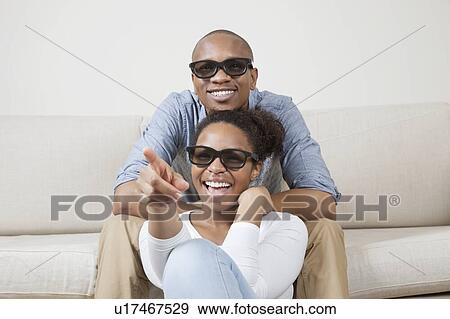 Portrait of young African American couple wearing 3D glasses and watching TV View Large Photo Image Stock Photo - Portrait of young African American couple wearing 3D glasses and watching TV. Fotosearch