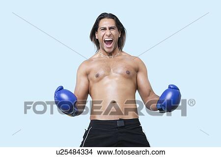 Portrait of young Asian boxer screaming over blue background View Large Photo Image Picture - Portrait of young Asian boxer screaming over blue background. Fotosearch