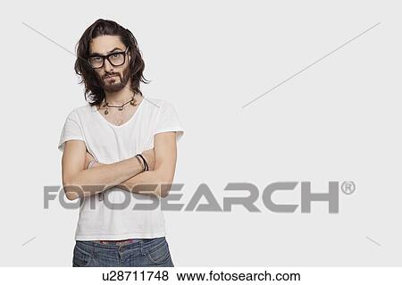 Portrait of young Asian man in casuals with arms crossed against white background View Large Photo Image Stock Photo - Portrait of young Asian man in casuals with arms crossed against white background. Fotosearch