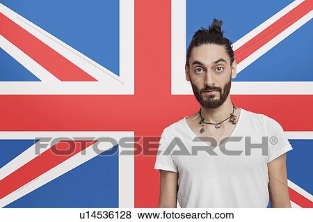 Stock Photo - Portrait of young Asian man in white t-shirt against British flag. Fotosearch