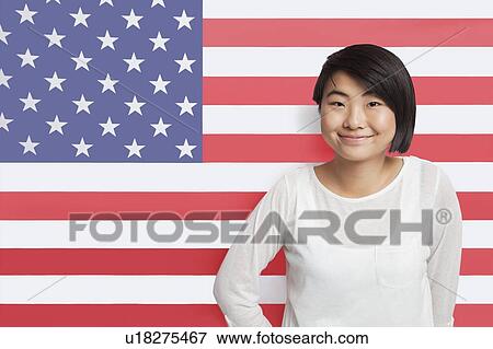 Portrait of young Asian woman smiling against American flag View Large Photo Image Stock Photo - Portrait of young Asian woman smiling against American flag. Fotosearch