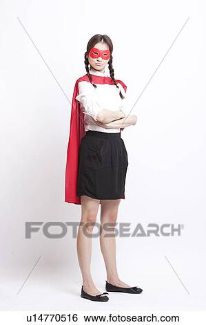 Stock Photograph - Portrait of young Asian woman wearing superhero costume against white background. Fotosearch