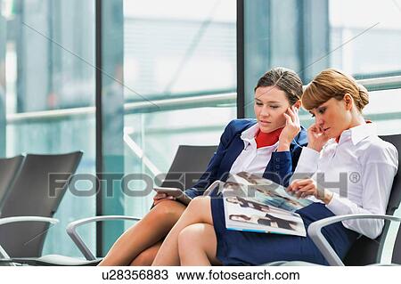Portrait of young attractive airport staffs talking and sitting while on break in airport View Large Photo Image Stock Image - Portrait of young attractive airport staffs talking and sitting while on break in airport. Fotosearch