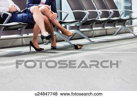 Stock Photo - Portrait of young attractive airport staffs talking and sitting while on break in airport. Fotosearch