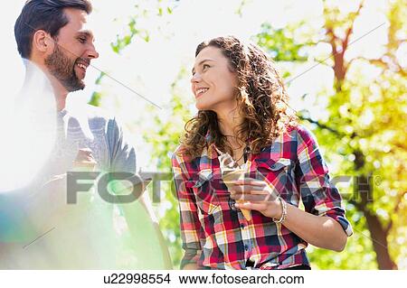 Portrait of young attractive couple walking while eating ice cream View Large Photo Image Picture - Portrait of young attractive couple walking while eating ice cream. Fotosearch