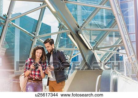 Portrait of young attractive couple looking on their pictures in the camera View Large Photo Image Picture - Portrait of young attractive couple looking on their pictures in the camera. Fotosearch