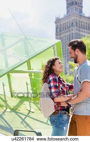 Portrait of young attractive couple standing while hugging each other in the middle of the city View Large Photo Image Picture - Portrait of young attractive couple standing while hugging each other in the middle of the city. Fotosearch