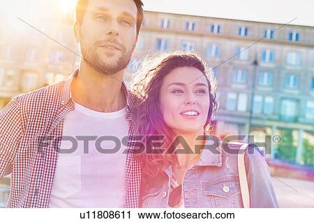 Portrait of young attractive couple standing against museum with lens flare in background View Large Photo Image Stock Image - Portrait of young attractive couple standing against museum with lens flare in background. Fotosearch