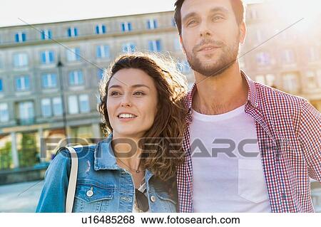 Portrait of young attractive couple standing against museum with lens flare in background View Large Photo Image Stock Photo - Portrait of young attractive couple standing against museum with lens flare in background. Fotosearch