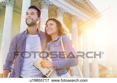 Portrait of young attractive couple standing against museum with lens flare in background View Large Photo Image Stock Photo - Portrait of young attractive couple standing against museum with lens flare in background. Fotosearch