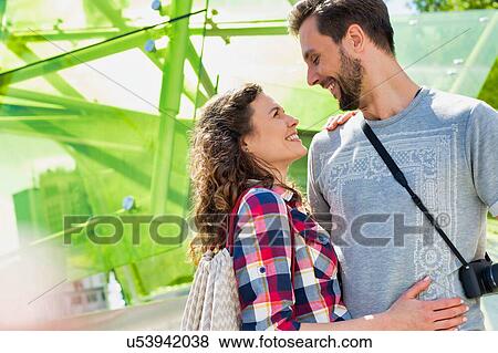 Portrait of young attractive couple standing while hugging each other in the middle of the city View Large Photo Image Stock Photo - Portrait of young attractive couple standing while hugging each other in the middle of the city. Fotosearch
