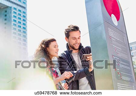 Stock Photo - Portrait of young attractive couple looking at the monitor. Fotosearch