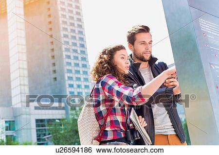 Portrait of young attractive couple looking at the monitor View Large Photo Image Stock Photograph - Portrait of young attractive couple looking at the monitor. Fotosearch