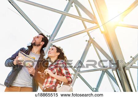 Portrait of young attractive couple looking on the map in the middle of the city with lens flare in background View Large Photo Image Stock Photography - Portrait of young attractive couple looking on the map in the middle of the city with lens flare in background. Fotosearch