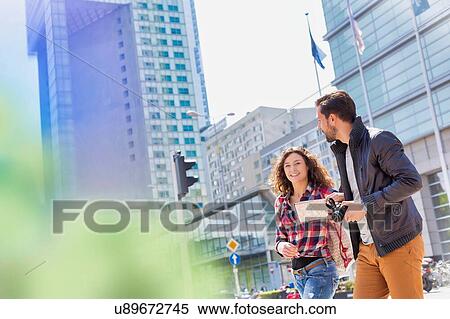 Stock Photography - Portrait of young attractive couple walking in the middle of the city. Fotosearch