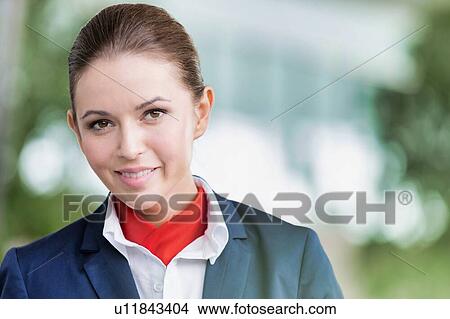 Portrait of young attractive flight attendant standing against flight display monitor in airport View Large Photo Image Picture - Portrait of young attractive flight attendant standing against flight display monitor in airport. Fotosearch