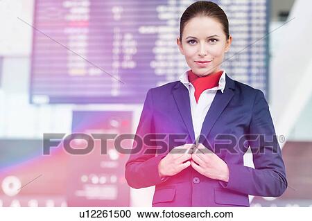 Portrait of young attractive flight attendant standing against flight display monitor in airport View Large Photo Image Stock Image - Portrait of young attractive flight attendant standing against flight display monitor in airport. Fotosearch