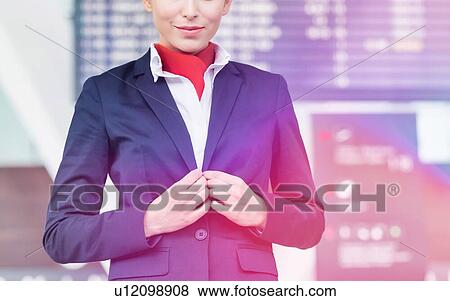 Portrait of young attractive flight attendant standing against flight display monitor in airport View Large Photo Image Stock Photo - Portrait of young attractive flight attendant standing against flight display monitor in airport. Fotosearch