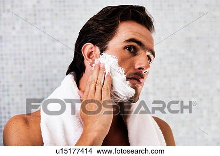 Portrait of young attractive man applying facial foam in his face View Large Photo Image Picture - Portrait of young attractive man applying facial foam in his face . Fotosearch