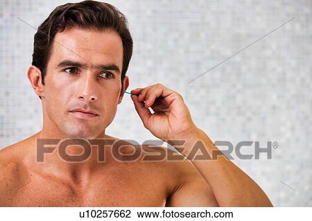 Portrait of young attractive man cleaning his ears with cotton buds in the bathroom View Large Photo Image Stock Image - Portrait of young attractive man cleaning his ears with cotton buds in the bathroom. Fotosearch