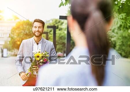 Portrait of young attractive man holding boquet of flowers for his girlfriend in park View Large Photo Image Stock Image - Portrait of young attractive man holding boquet of flowers for his girlfriend in park. Fotosearch