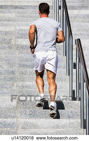 Stock Photo - Portrait of young attractive man running on stairs. Fotosearch