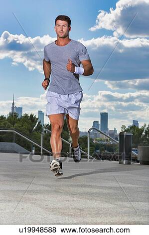 Stock Photo - Portrait of young attractive man running in park. Fotosearch