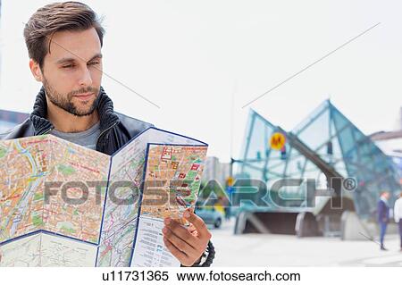 Portrait of young attractive man looking on the map in the city View Large Photo Image Stock Photography - Portrait of young attractive man looking on the map in the city. Fotosearch