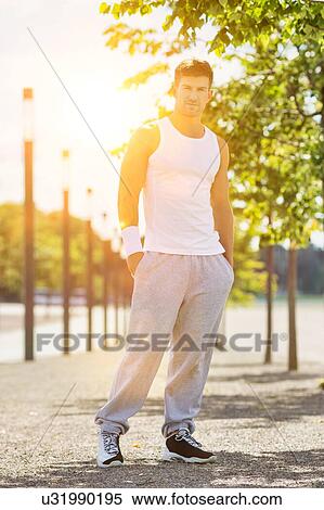 Portrait of young attractive man wearing sports wear standing in park View Large Photo Image Stock Photography - Portrait of young attractive man wearing sports wear standing in park. Fotosearch