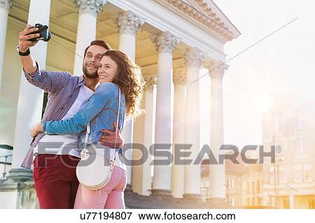 Portrait of young attractive man taking selfie with his girlfriend View Large Photo Image Stock Photo - Portrait of young attractive man taking selfie with his girlfriend . Fotosearch