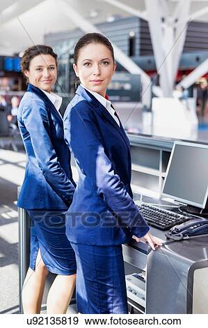 Stock Photo - Portrait of young attractive passemger service agent standing in airport. Fotosearch