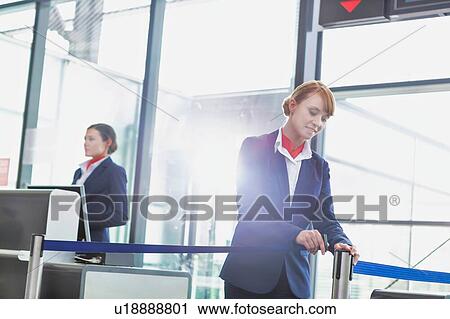 Stock Image - Portrait of young attractive passenger service agent opening the gate for boarding in airport. Fotosearch