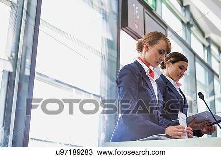 Stock Image - Portrait of young attractive passenger service agent opening the gate for boarding in airport. Fotosearch