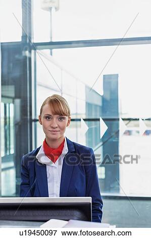 Stock Photo - Portrait of young attractive passenger service agent standing in airport gate. Fotosearch