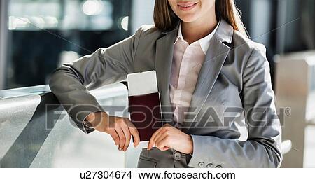 Portrait of young attractive businesswoman holding her passport and boarding pass in airport View Large Photo Image Picture - Portrait of young attractive businesswoman holding her passport and boarding pass in airport. Fotosearch