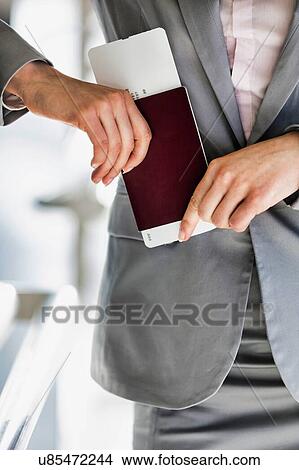 Portrait of young attractive businesswoman holding her passport and boarding pass in airport View Large Photo Image Picture - Portrait of young attractive businesswoman holding her passport and boarding pass in airport. Fotosearch