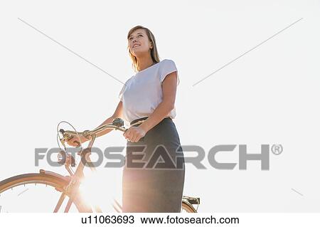Portrait of young attractive businesswoman holding bicycle while walking on the beach View Large Photo Image Stock Image - Portrait of young attractive businesswoman holding bicycle while walking on the beach . Fotosearch