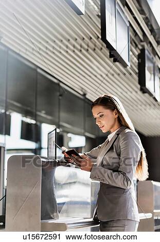 Portrait of young attractive businesswoman looking at her passport in airport View Large Photo Image Stock Image - Portrait of young attractive businesswoman looking at her passport in airport. Fotosearch