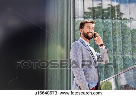 Portrait of young attractive businessman talking on smartphone View Large Photo Image Stock Image - Portrait of young attractive businessman talking on smartphone. Fotosearch