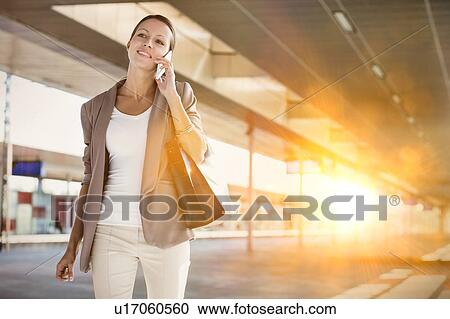 Stock Image - Portrait of young attractive businesswoman talking smartphone. Fotosearch