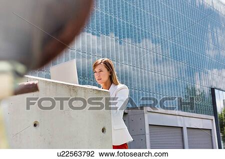 Portrait of young attractive businesswoman working on her laptop outdoor View Large Photo Image Stock Image - Portrait of young attractive businesswoman working on her laptop outdoor. Fotosearch
